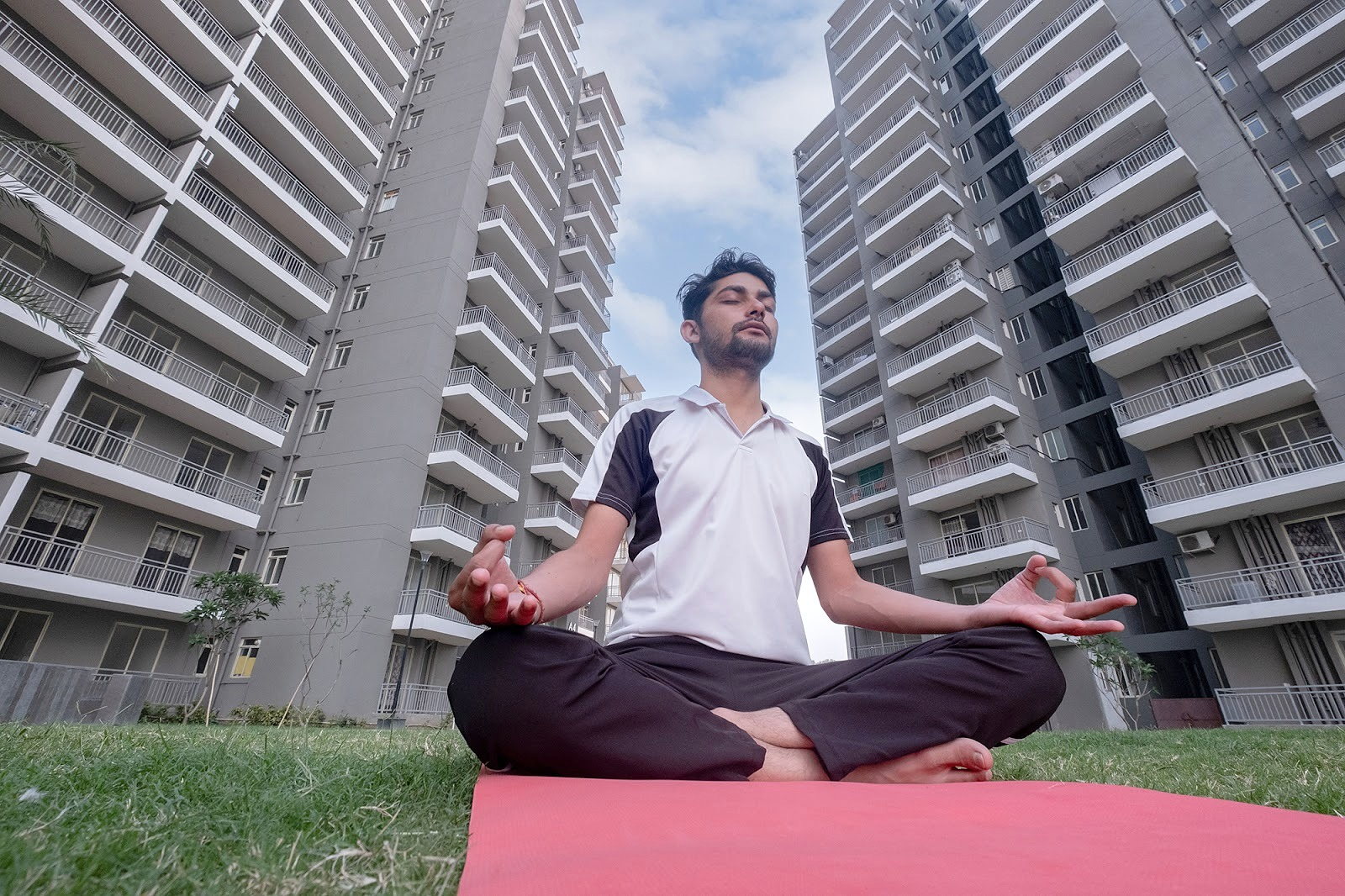 A resident practising yoga on a lawn at Smart Homes Karnal.